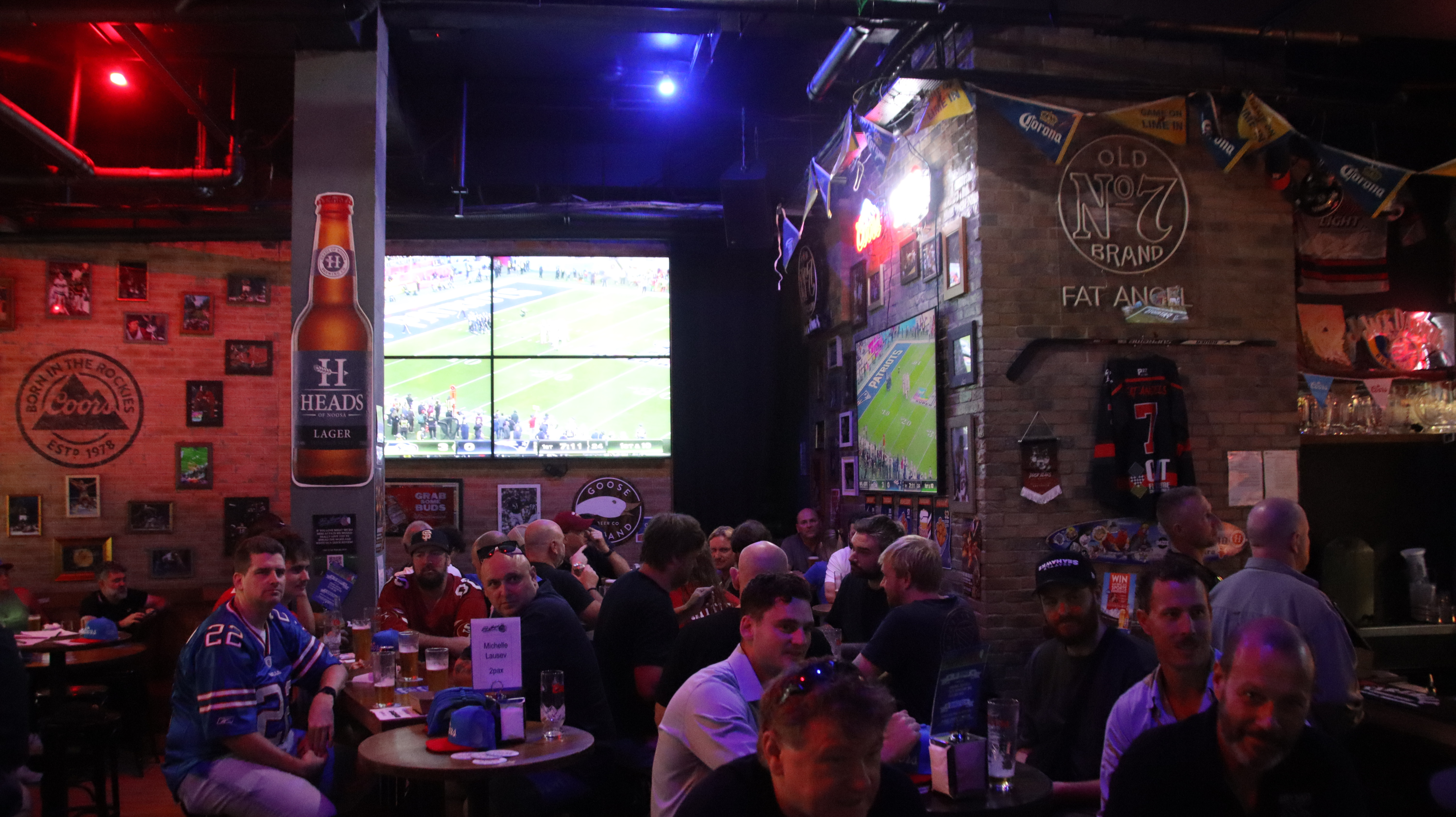 A packed crowd cheering at the big screen inside Fat Angel Sports Bar